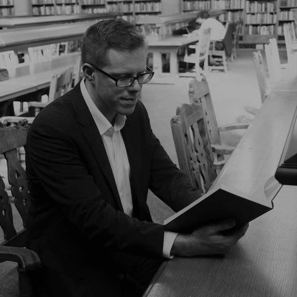 Dylan reading a book in library reading room.